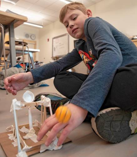 Finley Nelson, a fourth grader, watches to see if the ball will hit the target when launched from the catapult he built in the STEAM class taught by Megan Kelley Bagg at Mountain View School in Easthampton.