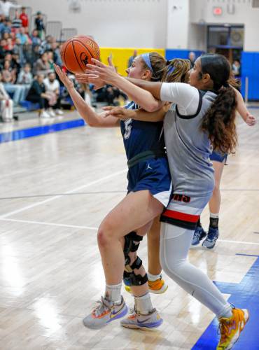 Northampton’s Bri Heafey (5) fights for a rebound against Worcester South defender Bryan Bascones (4) in the fourth quarter of the MIAA Div. 2 girls basketball state semifinals Tuesday night at Chicopee Comp High School.