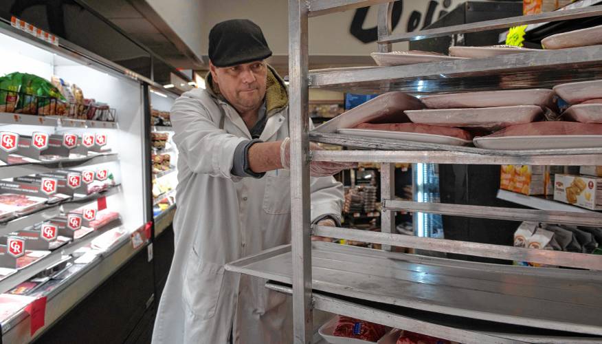 Tim Mortell, a butcher at Fruit Fair in Chicopee, stocks the meat shelves.
