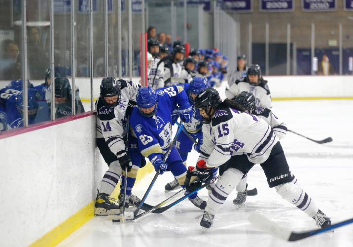 Amherst College’s Kelsey Stewart (14) and Alyssa Xu (15) fight for possession against Hamilton’s Grace Crowley (23) in the second period of the NESCAC women's hockey semifinals Friday night at Orr Rink in Amherst.