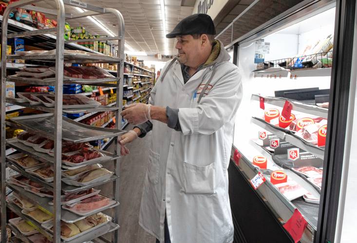 Tim Mortell, a butcher at Fruit Fair in Chicopee, stocks the meat shelves.