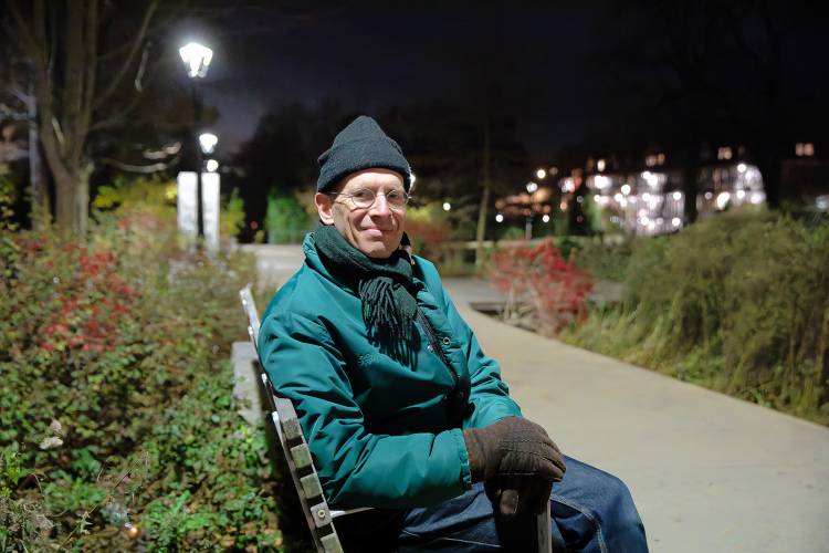 Professor James Lowenthal, who is chair of the Department of Astronomy at Smith College, sits for a portrait under the lights at Pulaski Park on Tuesday night in Northampton. Lowenthal has for years lobbied the city to upgrade its outdoor lighting regulations, which the City Council is hoping to vote on before the end of the year. 