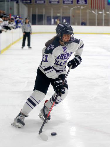 Amherst College’s Clare O'Connor (21) takes the puck up the ice against Hamilton in the second period of the NESCAC women's hockey semifinals Friday night at Orr Rink in Amherst.