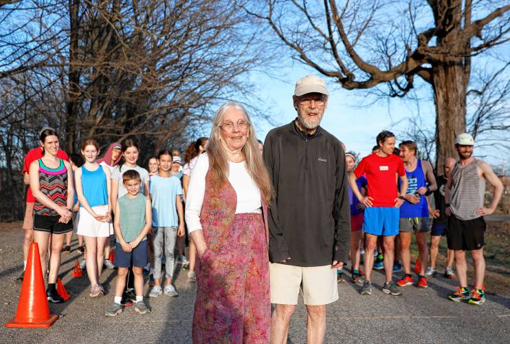Sue and Don Grant pose for a photo last Tuesday  in front of the starting line before the start of the Northampton Cross-Country 5K Race Series, a weekly 5K that starts in April each year and goes through late summer. The Grants, who started the series 36 years ago, are stepping aside.