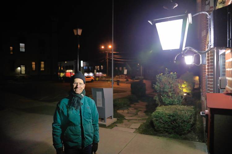 Professor James Lowenthal, who is chair of the department of astronomy at Smith College, stands for a portrait under the lights outside of the City Council Chambers on Tuesday night in Northampton. Lowenthal has for years lobbied the city to upgrade its outdoor lighting regulations, which the City Council is hoping to vote on before the end of the year.