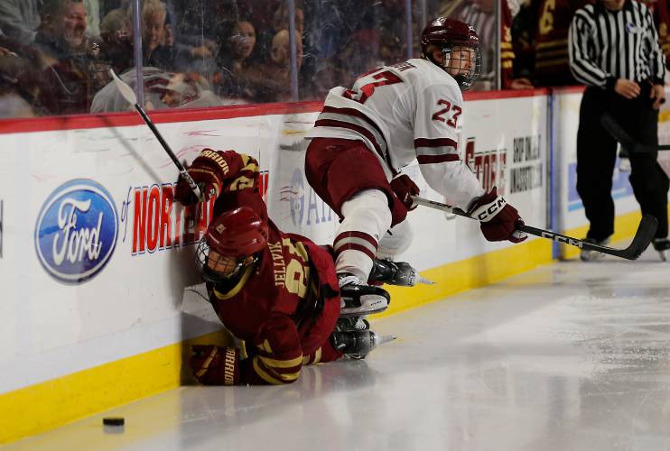 UMass defender Scott Morrow (23) knocks Boston College’s Oskar Jellvik (21) into the boards in the second period earlier this season at the Mullins Center.