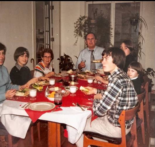 The McMahon family gathers at the dinner table, with Ed McMahon at the head of the table.