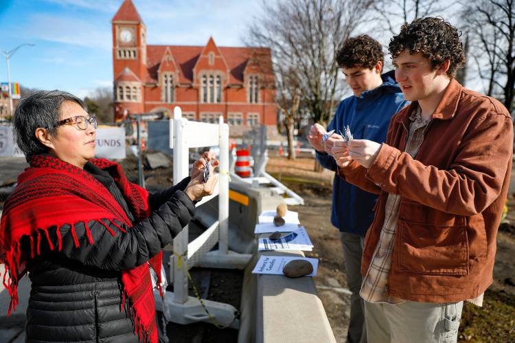 Local artist JuPong Lin  makes origami peace birds with Amherst College students Luke Bardetti and Parker Smith on Friday afternoon in downtown Amherst to raise awareness of the coming Town Council vote on the Gaza cease-fire resolution.