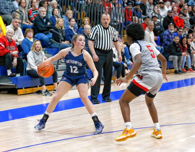 Northampton’s Chloe Derby (12) dribbles the ball against Worcester South defender Naima Bleou (5) in the fourth quarter of the MIAA Div. 2 girls basketball state semifinals Tuesday night at Chicopee Comp High School.