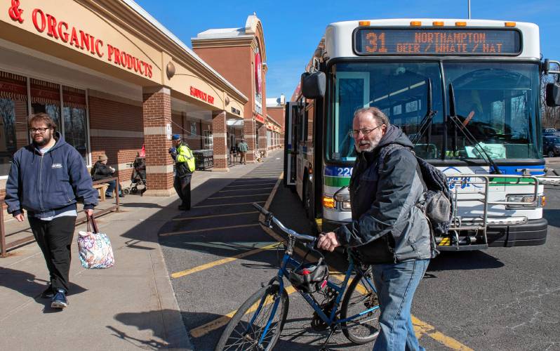David Grace, of Greenfield, gets his bike off the bus at the Big Y stop in Northampton. “These buses are very important for grocery shopping; it’s  crucial,” said Grace.