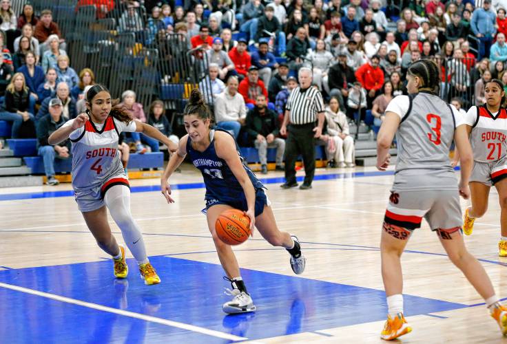 Northampton’s Ava Azzaro (13) drives the lane between Worcester South defenders Anitsy Robles (3) and Bryan Bascones (4) in the fourth quarter of the MIAA Div. 2 girls basketball state semifinals Tuesday night at Chicopee Comp High School.