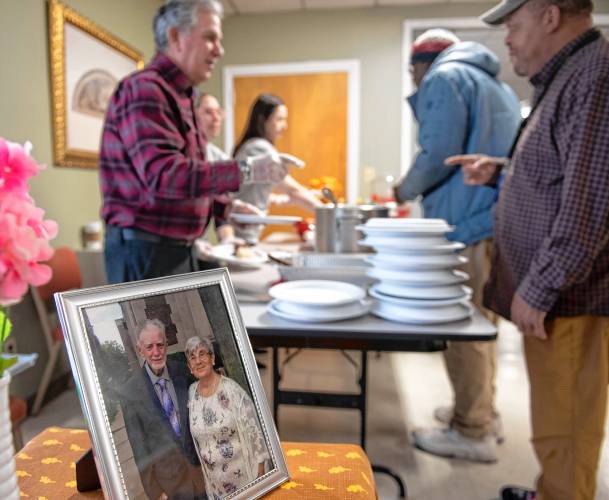 A photo of Edward O. Hanlon and Ilona L. Murray, two “stalwarts” of the veteran community who died in a pedestrian accident last year, at the first monthly luncheon for veterans at the Easthampton Congregational Church. The luncheon is   sponsored by the   Easthampton Coalition for Veterans Wellness in partnership with Building Bridges. In the background Bruce Sylvia serves Arnold Palmer.