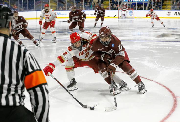 UMass forward Aydar Suniev (16) fights for possession against Denver defenseman Sean Behrens (2) in the second period of the opening round of the NCAA tournament Friday at the MassMutual Center in Springfield.