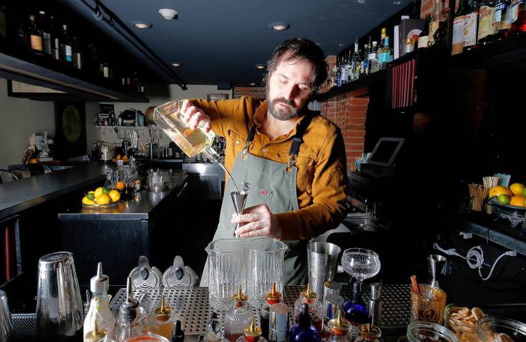 Bartender Nick Martino mixes up a Big in Japan house old fashioned Tuesday at The Archives bar in Amherst. The Big in Japan uses sesame and butter washed Suntory Toki Whisky, Mirin, Demerara sugar and orange bitters.