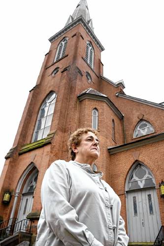 Nancy Dunn stands in front of the former Notre Dame Church on East Main Street in North Adams in 2021.