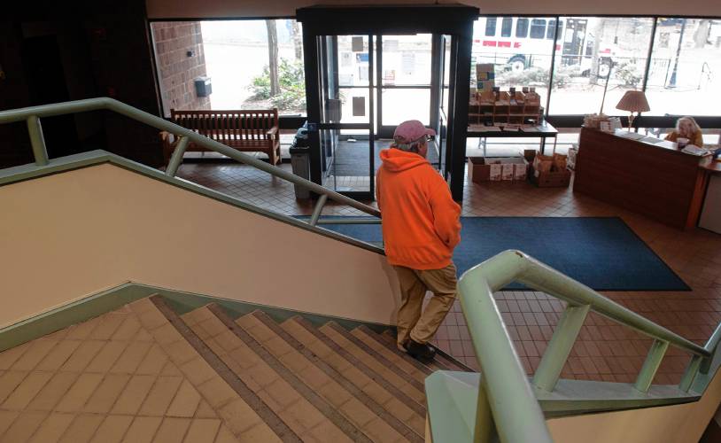 Robert Roberts, the Amherst Senior Center bus driver, walk down the stairs to his bus. “Last week I hade to bring someone all the way around the building — I would like to see it fixed,” said Roberts, referring to the broken elevator at the Bangs Community Center where the senior center is located. 