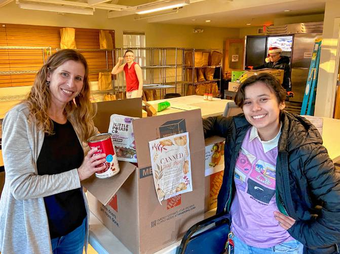 Pioneer Valley Performing Art’s Sustainability Club member and Amherst resident Moe Avila Langmore, right,  dropped off  donations to the Amherst Survival Center on Friday, Dec. 22.