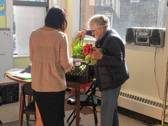Pat Larson of Orange helped to develop the HIP share program at Quabbin Harvest starting with its statewide launch in 2017. Here she helps a HIP customer pack the week’s vegetable share into a reusable bag.
