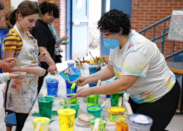 Color Collaborative member Lucia Montalvo, right, mixes a pallet of paint for Leia Nagle, 11, during a community painting party Saturday to create a 1,500-square-foot mural for JFK Middle School.