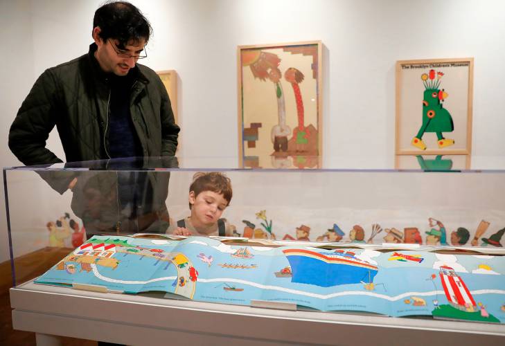 Adam Horowitz and his son Ben, 3, view a fold-out picture book display at “Kid in a Candy Store,” a new exhibit at the Eric Carle Museum in Amherst.