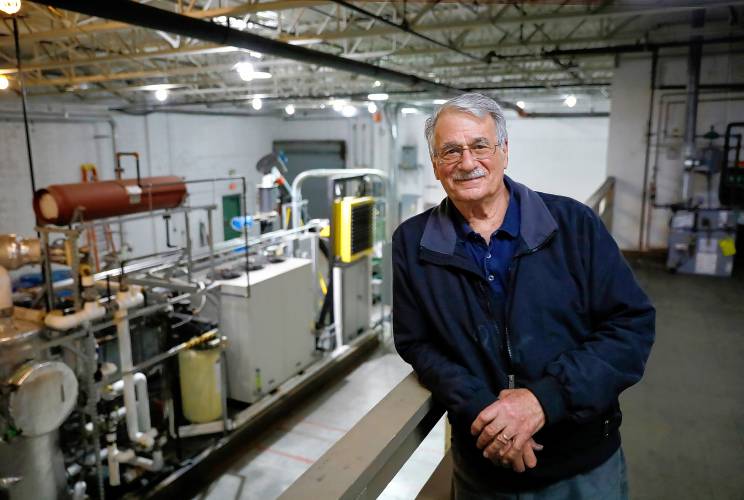 Michael Garjian stands beside his  CarbonStar Catalytic Vacuum Pyrolysis System on Tuesday afternoon in Holyoke. His invention’s been selected as a contender in Elon Musk’s $100 million XPrize for Carbon Removal competition.